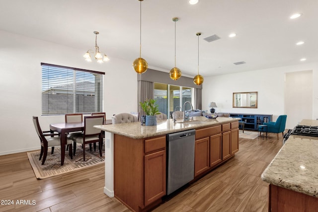 kitchen featuring sink, hanging light fixtures, dishwasher, an island with sink, and light stone countertops