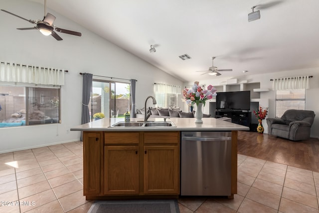 kitchen with stainless steel dishwasher, sink, lofted ceiling, and an island with sink