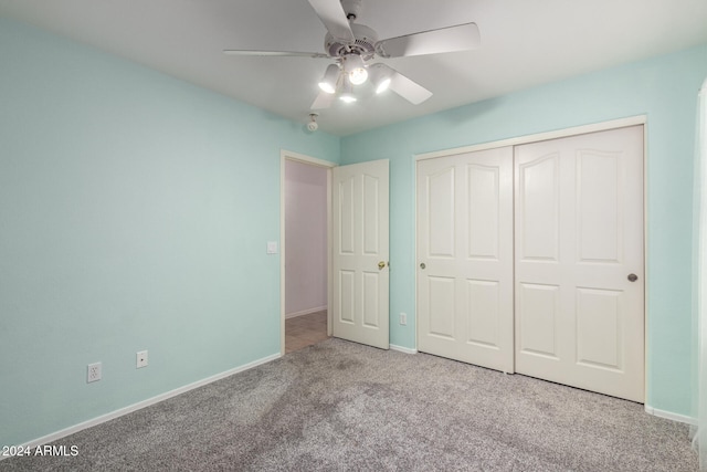 unfurnished bedroom featuring a closet, light colored carpet, and ceiling fan