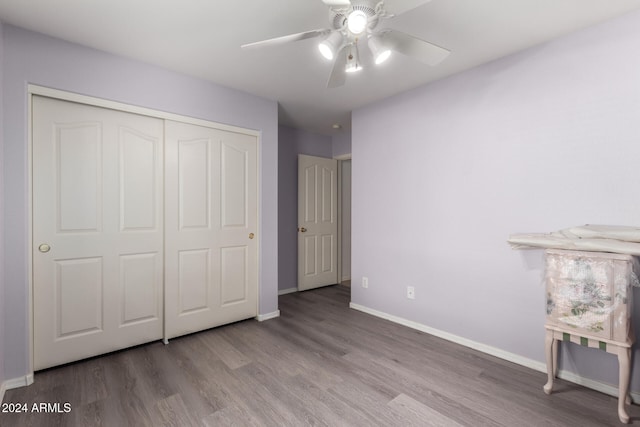 unfurnished bedroom featuring ceiling fan, light hardwood / wood-style floors, and a closet