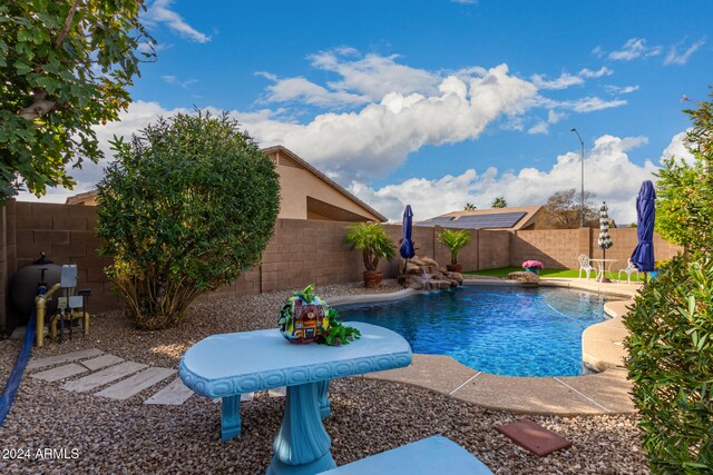 view of pool featuring pool water feature and a patio