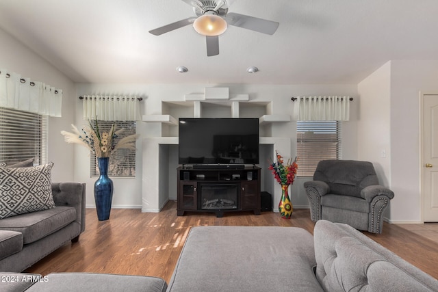 living room featuring ceiling fan and dark hardwood / wood-style flooring