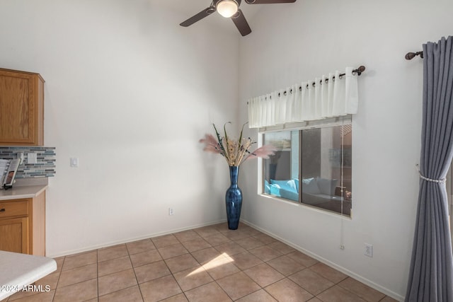 tiled empty room featuring ceiling fan