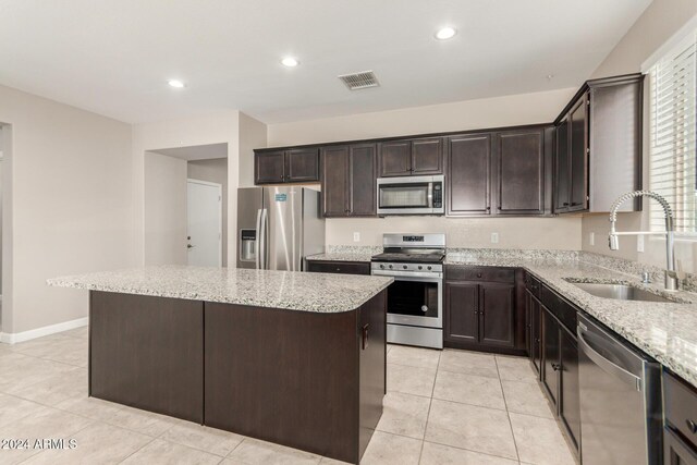 kitchen featuring sink, a kitchen island, stainless steel appliances, and dark brown cabinets