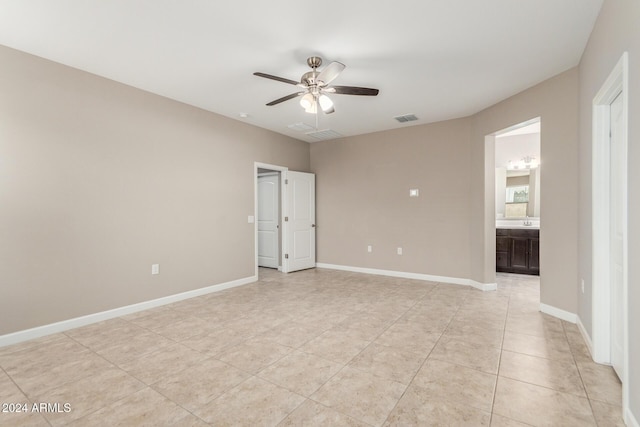 spare room with ceiling fan and light tile patterned floors