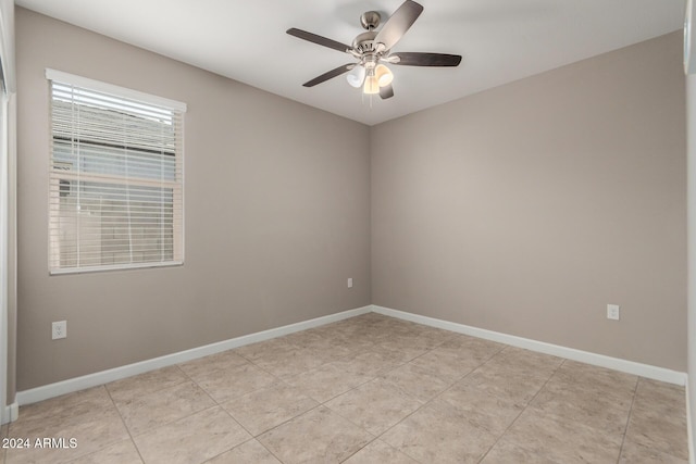 tiled empty room featuring ceiling fan