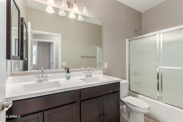 full bathroom featuring vanity, enclosed tub / shower combo, and toilet