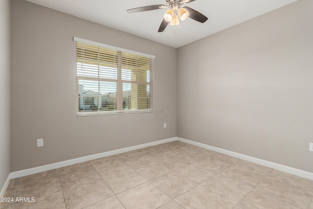 empty room with ceiling fan and light tile patterned floors