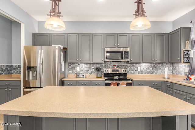 kitchen featuring gray cabinets, stainless steel appliances, and backsplash