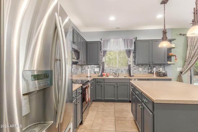 kitchen featuring pendant lighting, appliances with stainless steel finishes, sink, and gray cabinetry