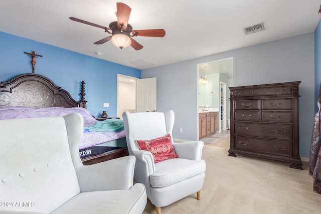 bedroom with light carpet, ceiling fan, and ensuite bath