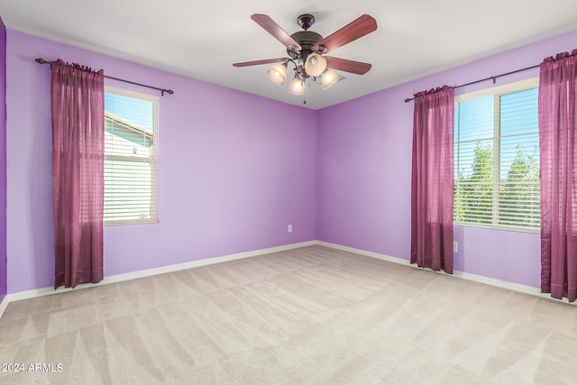 empty room with ceiling fan and light colored carpet