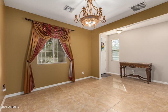 unfurnished room featuring light tile patterned flooring and a notable chandelier