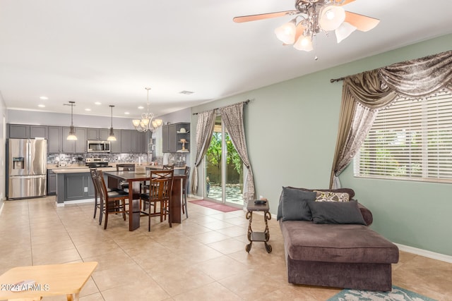 tiled dining room with ceiling fan with notable chandelier