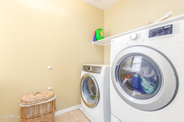 clothes washing area with light tile patterned flooring and independent washer and dryer