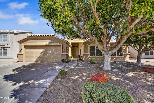 mediterranean / spanish house with a tiled roof, an attached garage, driveway, and stucco siding