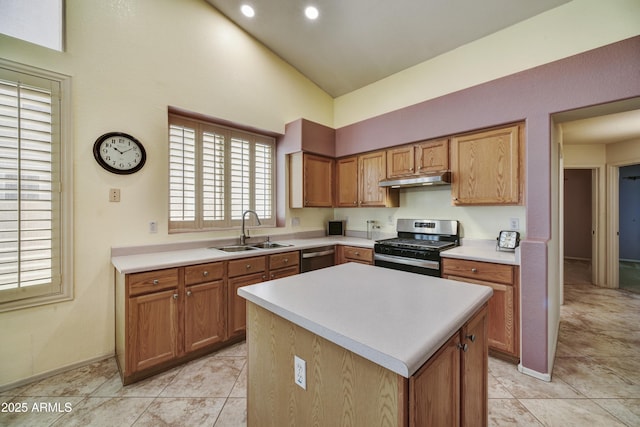 kitchen featuring a sink, light countertops, under cabinet range hood, stainless steel appliances, and a kitchen island