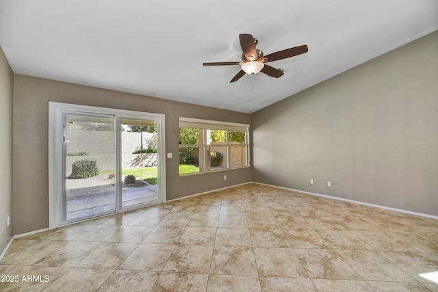 tiled spare room featuring baseboards, a ceiling fan, and lofted ceiling