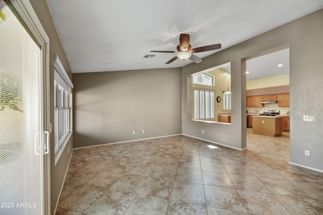 empty room with visible vents, ceiling fan, light tile patterned floors, and baseboards