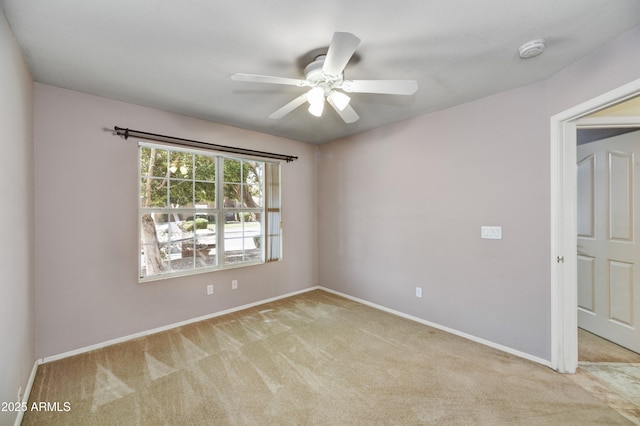 carpeted empty room featuring ceiling fan and baseboards