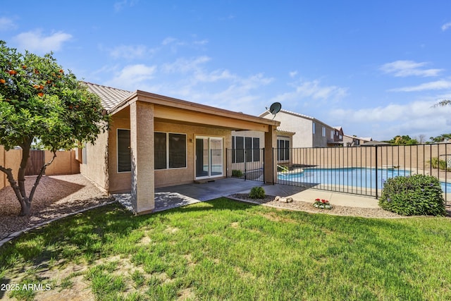 back of property featuring a yard, a tiled roof, a fenced backyard, a patio, and stucco siding