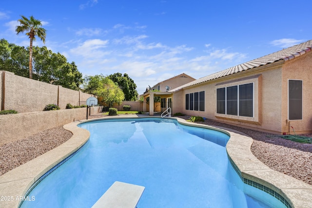 view of swimming pool with a diving board, a fenced backyard, and a fenced in pool
