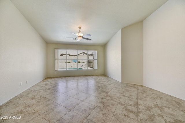 tiled spare room featuring visible vents and a ceiling fan