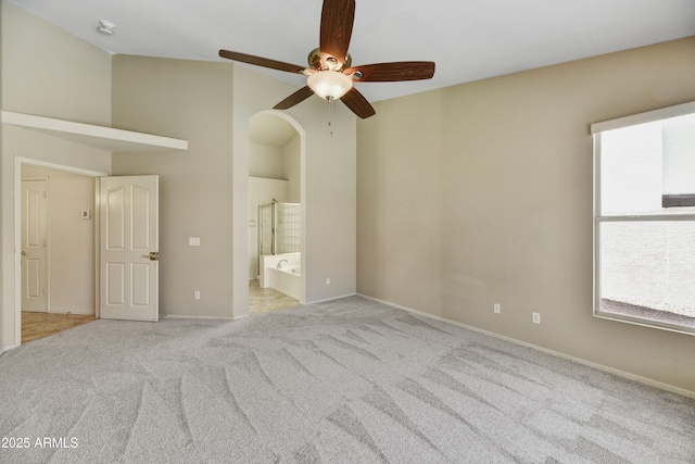 unfurnished bedroom featuring ensuite bath, baseboards, a ceiling fan, and carpet floors