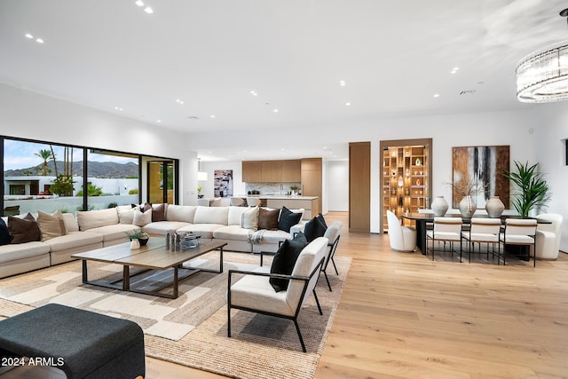 living room with an inviting chandelier and light hardwood / wood-style flooring