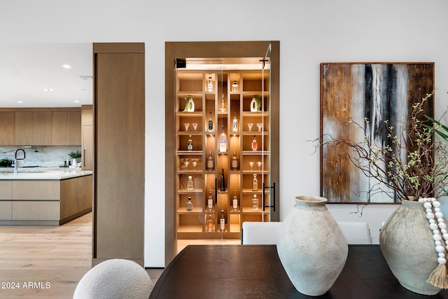 wine room featuring light hardwood / wood-style floors and sink