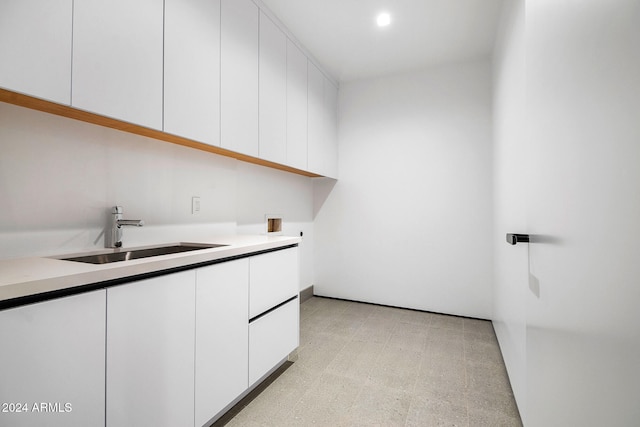 washroom with sink and cabinets