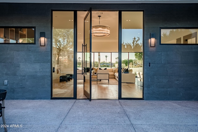 exterior entry at dusk featuring an outdoor living space and a patio