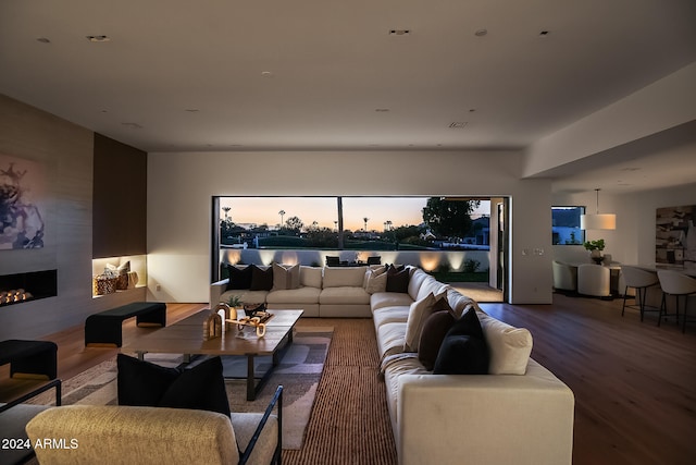 living room with a large fireplace and hardwood / wood-style flooring