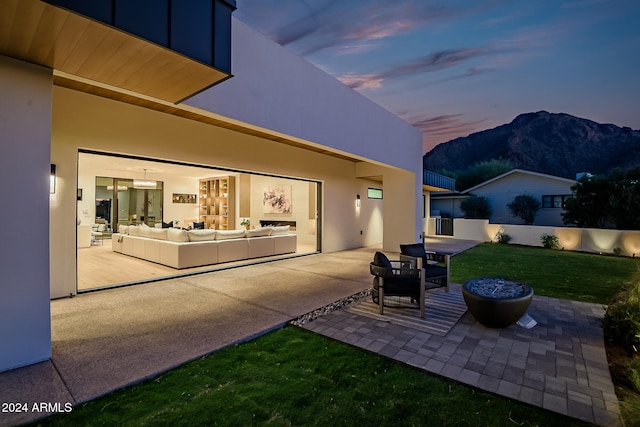 patio terrace at dusk with a mountain view and an outdoor hangout area