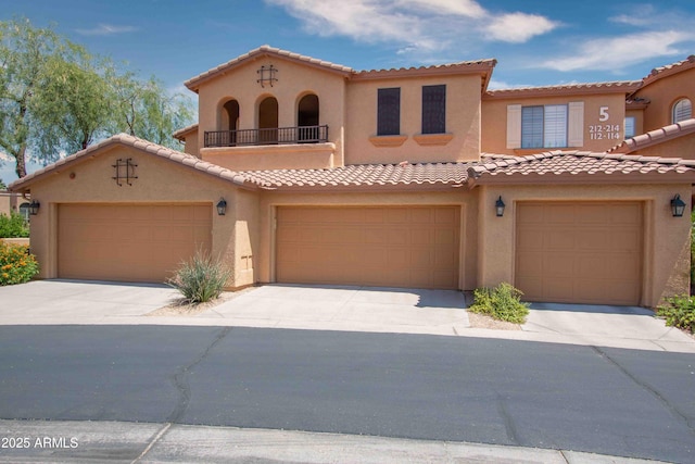 10655 N 9th St Unit 112, Phoenix, AZ 85020 - mediterranean / spanish-style house with stucco siding, concrete driveway, a tiled roof, and a garage
