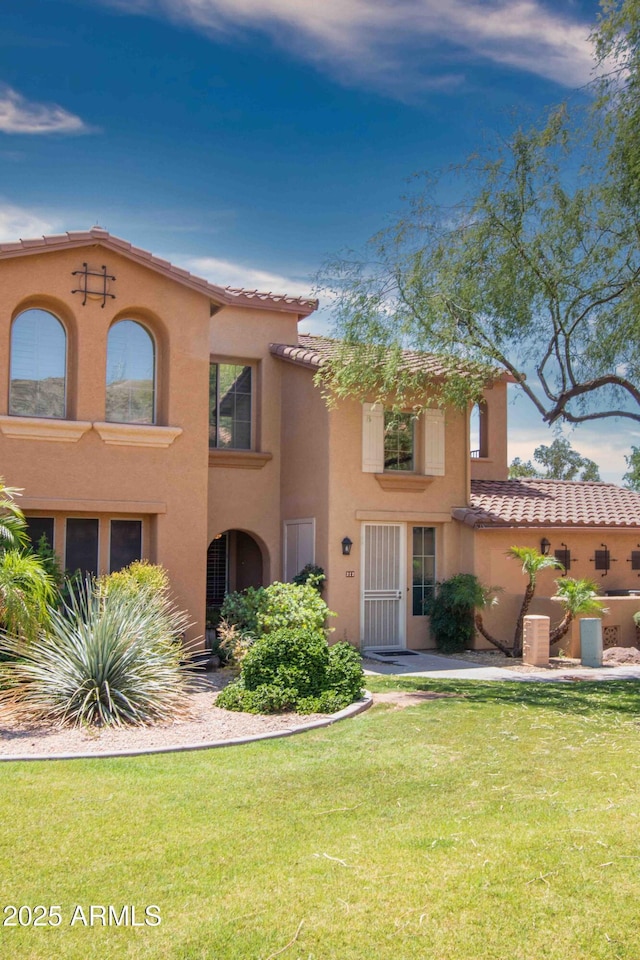 10655 N 9th St Unit 112, Phoenix, AZ 85020 - mediterranean / spanish house with stucco siding, a tile roof, and a front lawn