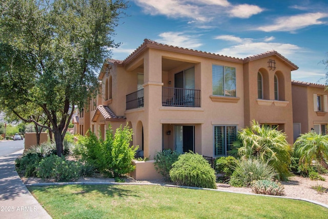 10655 N 9th St Unit 112, Phoenix, AZ 85020 - view of front of property featuring a tile roof, stucco siding, a balcony, and a front lawn