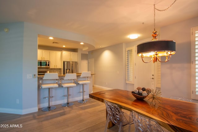 10655 N 9th St Unit 112, Phoenix, AZ 85020 - dining space featuring wood finished floors, recessed lighting, and a chandelier