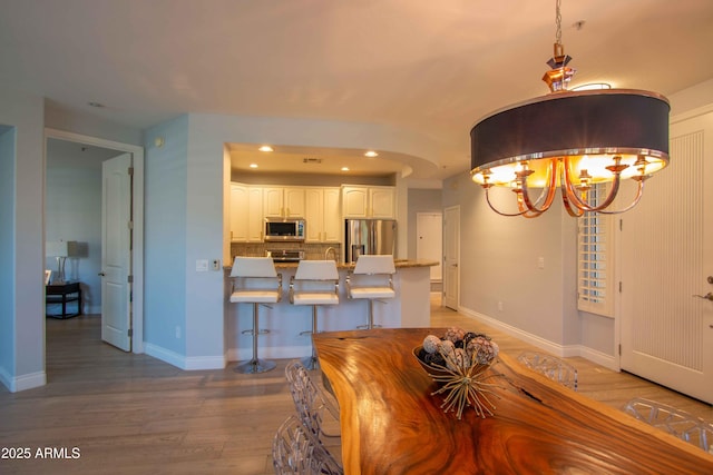 10655 N 9th St Unit 112, Phoenix, AZ 85020 - dining area featuring a chandelier, recessed lighting, and light wood-type flooring