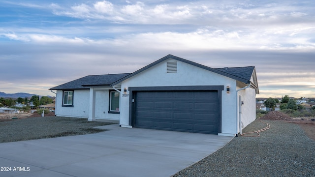 ranch-style home with a garage and a mountain view