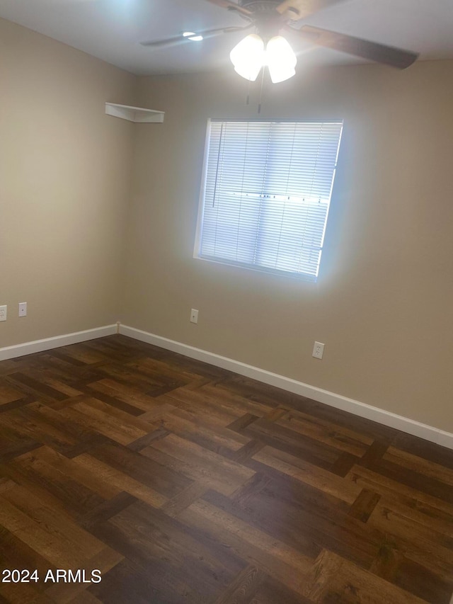 empty room featuring ceiling fan and dark parquet floors