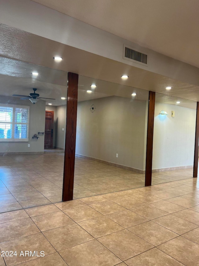 basement featuring light tile patterned floors and ceiling fan