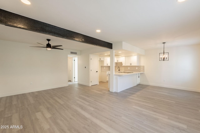 6544 N 7th Ave Unit 14, Phoenix, AZ 85013 - unfurnished living room with light wood-style flooring, recessed lighting, a chandelier, beamed ceiling, and ceiling fan
