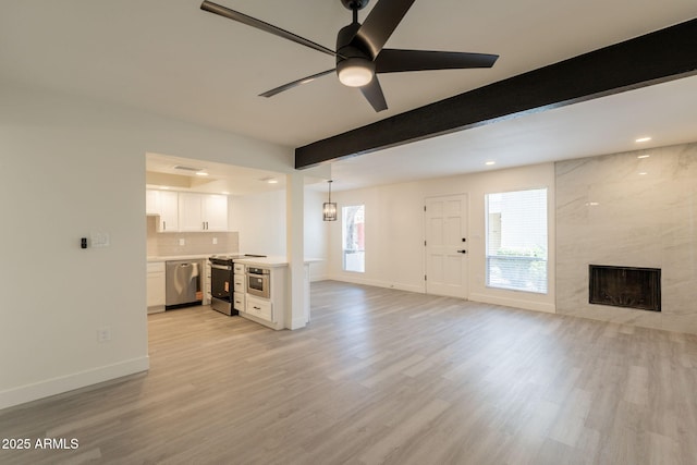 6544 N 7th Ave Unit 14, Phoenix, AZ 85013 - unfurnished living room with light wood-style floors, beam ceiling, a fireplace, ceiling fan, and recessed lighting