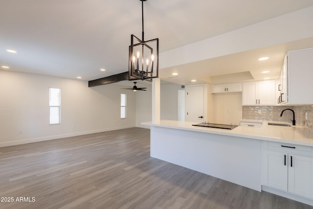 6544 N 7th Ave Unit 14, Phoenix, AZ 85013 - kitchen featuring light wood-type flooring, light countertops, black electric stovetop, a chandelier, and recessed lighting