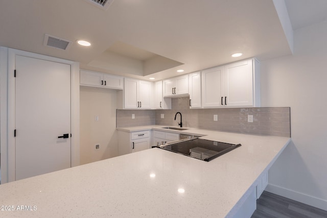 6544 N 7th Ave Unit 14, Phoenix, AZ 85013 - kitchen with dark wood-style floors, decorative backsplash, white cabinets, light stone counters, and recessed lighting