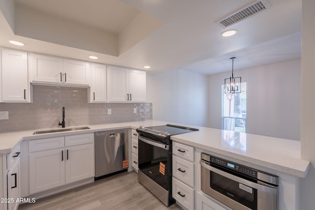 6544 N 7th Ave Unit 14, Phoenix, AZ 85013 - kitchen with stainless steel appliances, a peninsula, light wood finished floors, tasteful backsplash, and recessed lighting