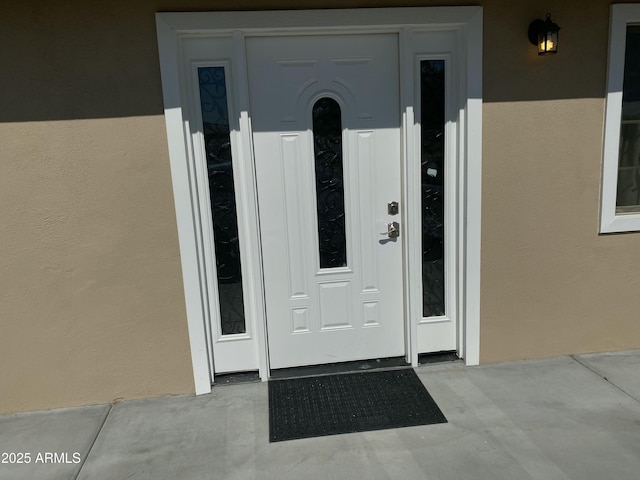 view of exterior entry featuring stucco siding