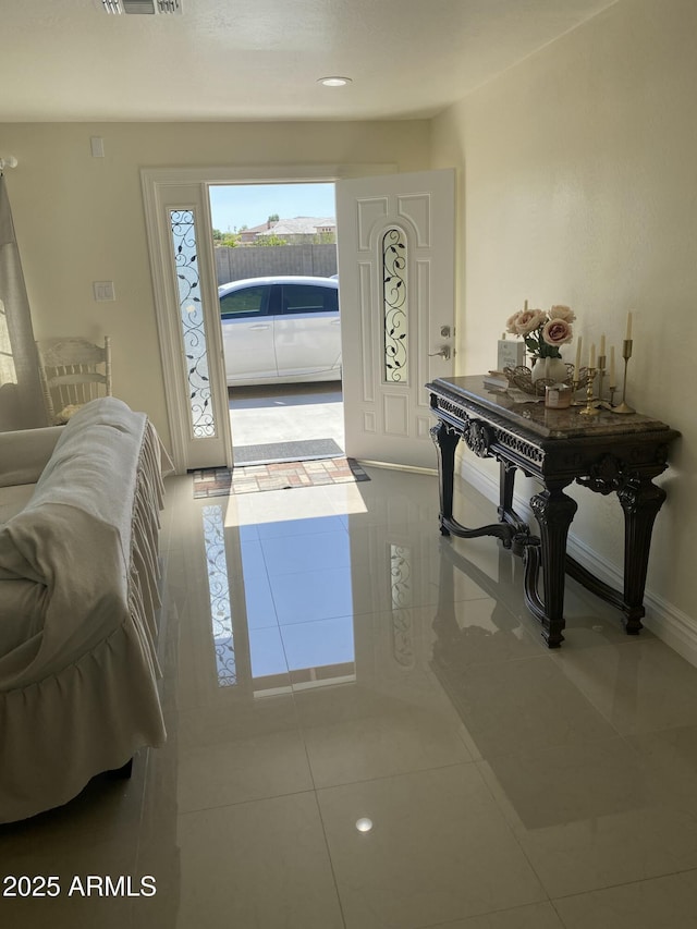 foyer entrance featuring visible vents, baseboards, and tile patterned floors