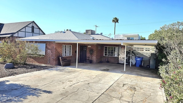 1520 W Encanto Blvd, Phoenix, AZ 85007 - back of house featuring brick siding, central air condition unit, concrete driveway, and an attached carport
